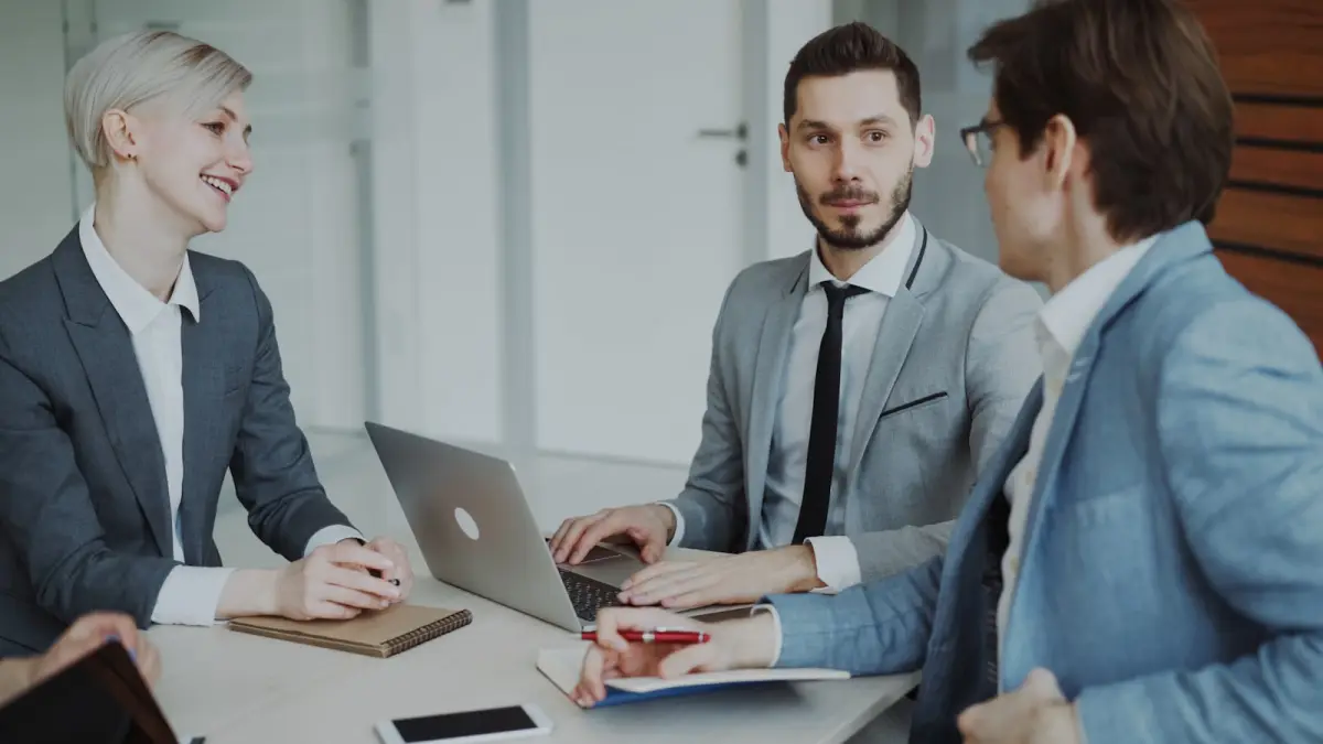 Geschäftsführer einer Immobilienverwaltung diskutiert mit Team über Smart-Building-Dashboards