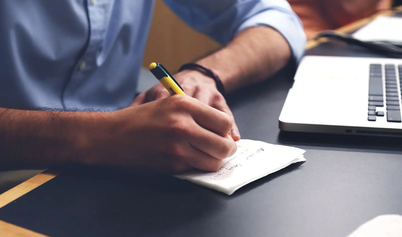 IT-Mitarbeiter am Schreibtisch dokumentiert handschriftlich Entra-ID-Policies und Conditional-Access-Regeln