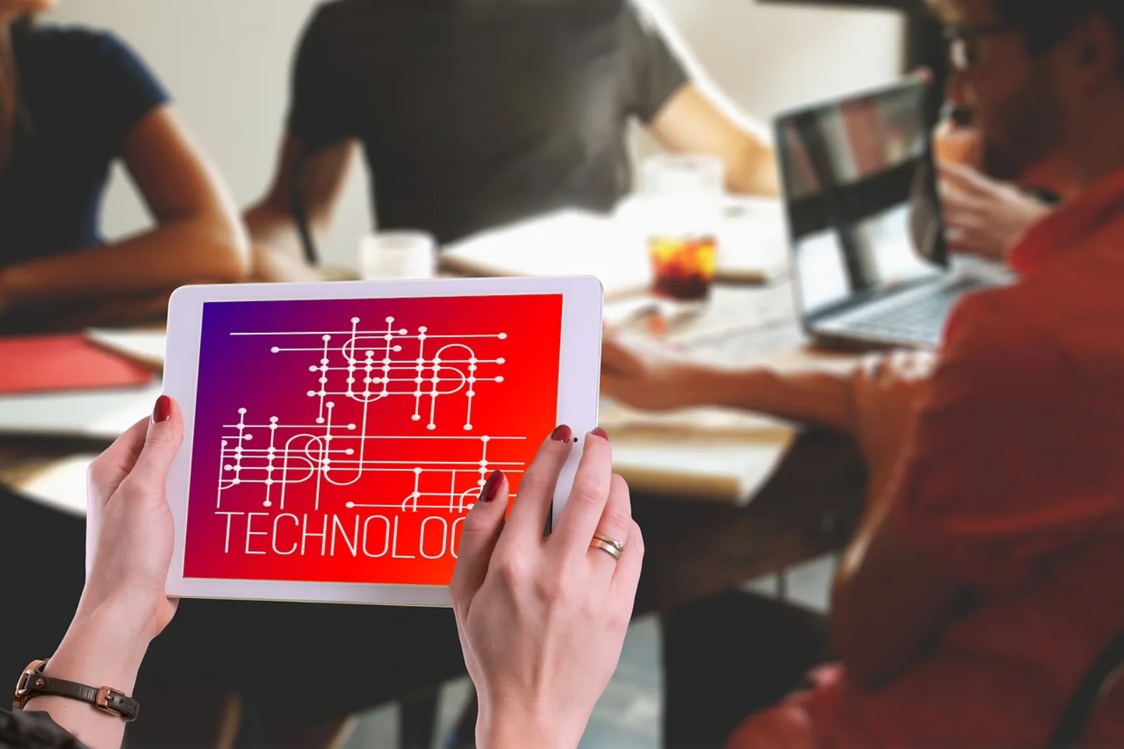 Cloud-Consultant bespricht Auto-Scaling-Strategie und Last-Profile mit Business-Team am Tablet