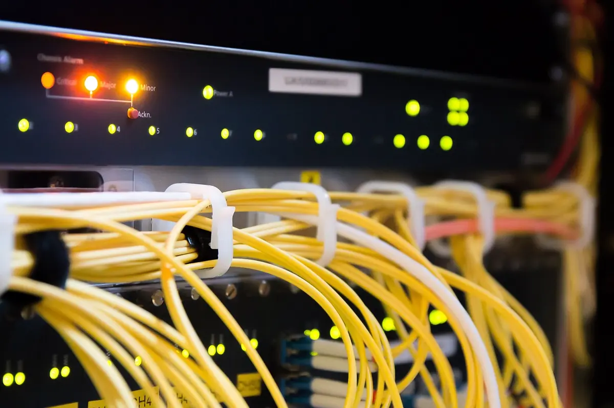 Ethernet-Patchpanel mit gelben Cat-Kabeln und grünen Status-LEDs — zentraler Verteilpunkt im Serverschrank