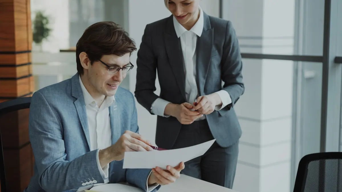 Zwei Kollegen besprechen Berichte am Schreibtisch im modernen Büro — typischer Arbeitsalltag in der Zusammenarbeit zwischen IT-Firma und Kunde.