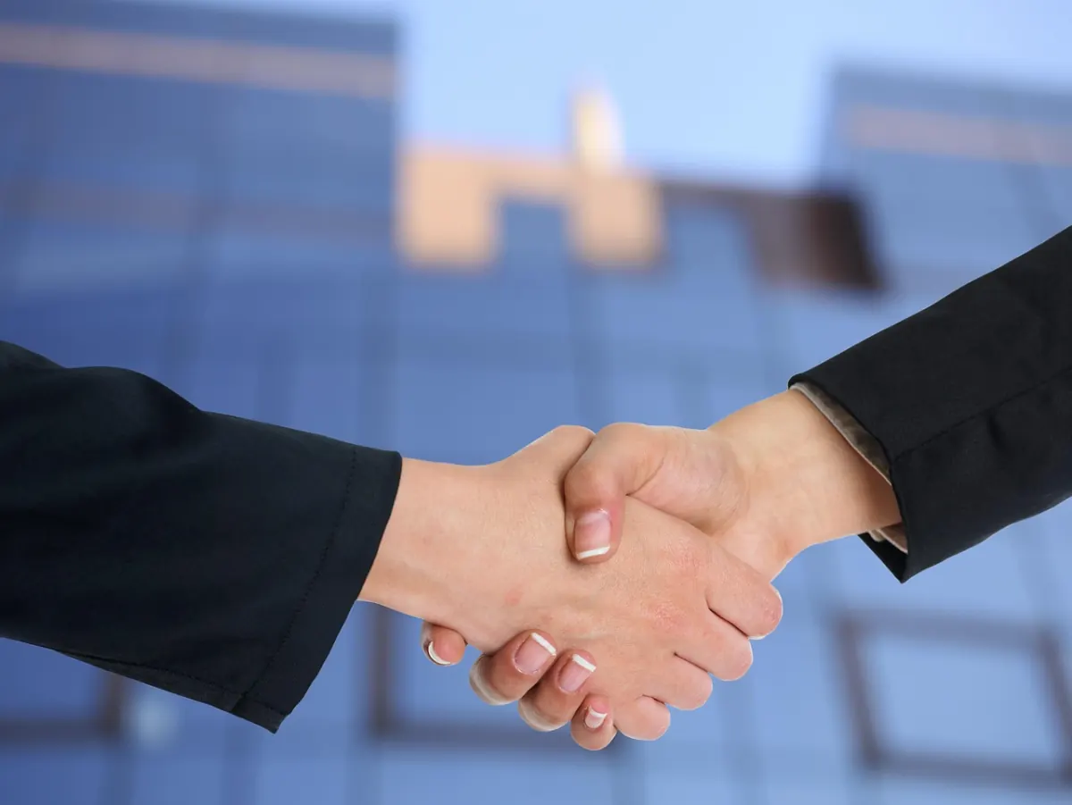 Zwei Geschäftspartner geben sich die Hand nach einem IT-Systemhaus-Beratungsgespräch — Symbol für eine langfristige Partnerschaft
