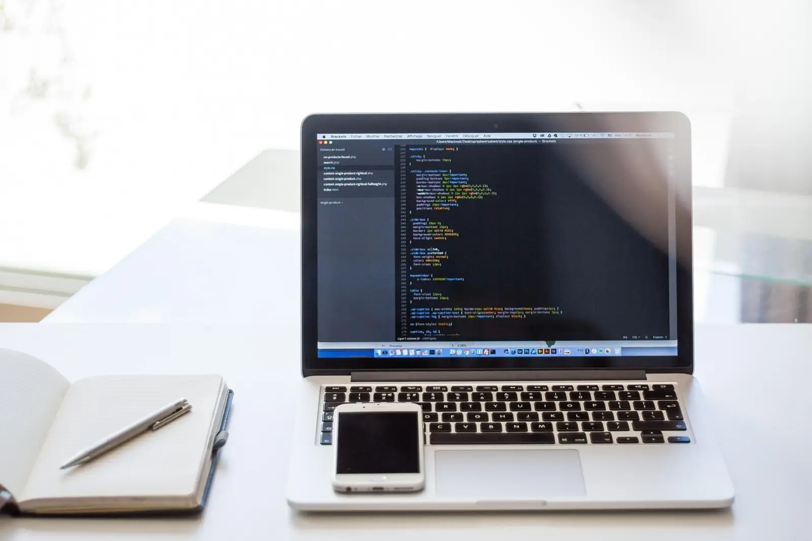 DevOps-Arbeitsplatz mit Laptop, Notebook und Smartphone — Kubernetes-Architektur für KMU planen