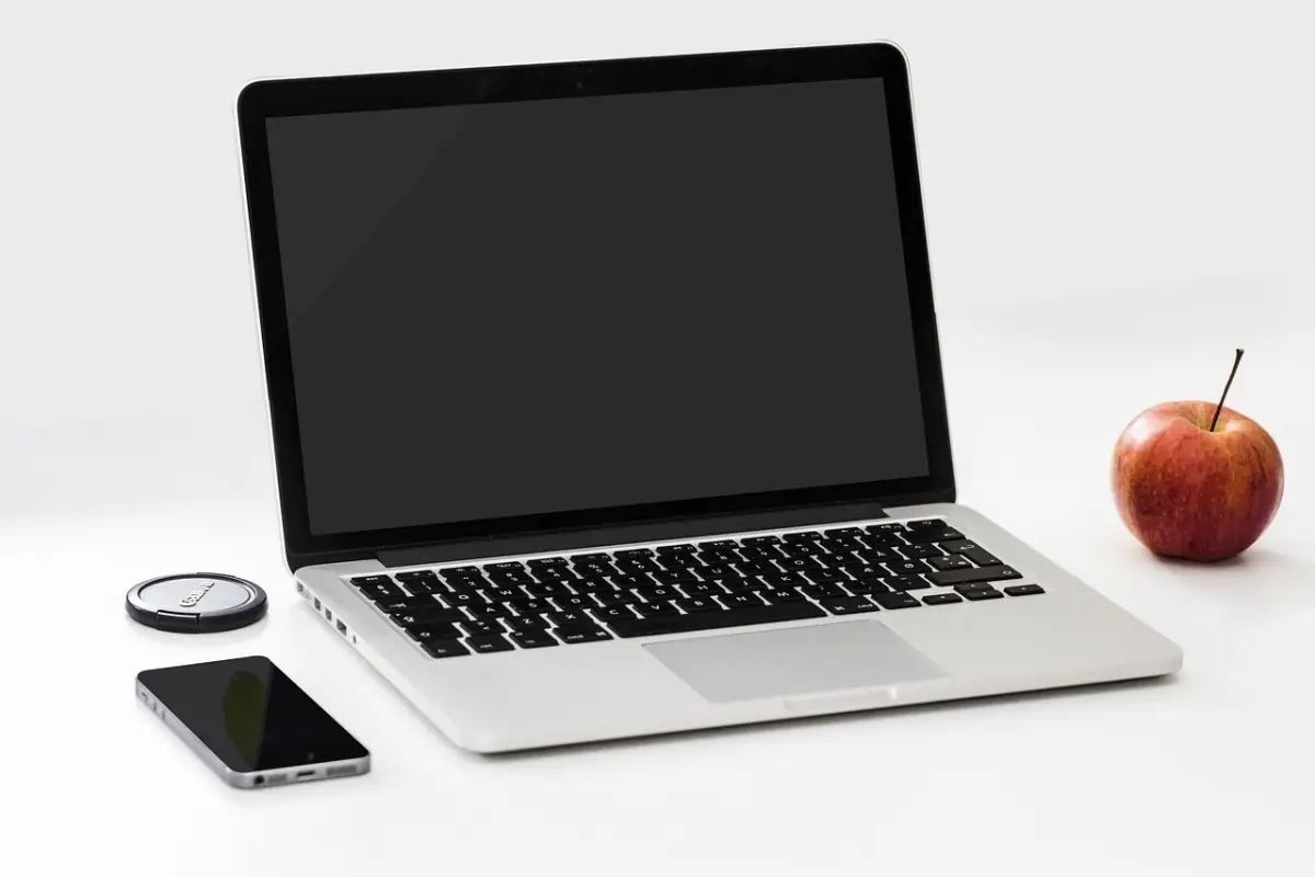 MacBook und iPhone auf neutralem Hintergrund — Mac im Unternehmen verwalten