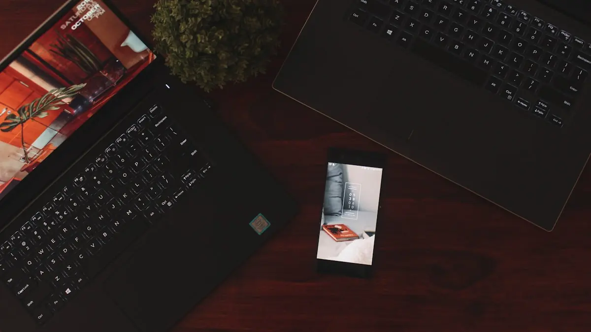 Smartphone mit MFA-Anmeldebestätigung neben Laptops — Number Matching schützt vor versehentlichem Bestätigen