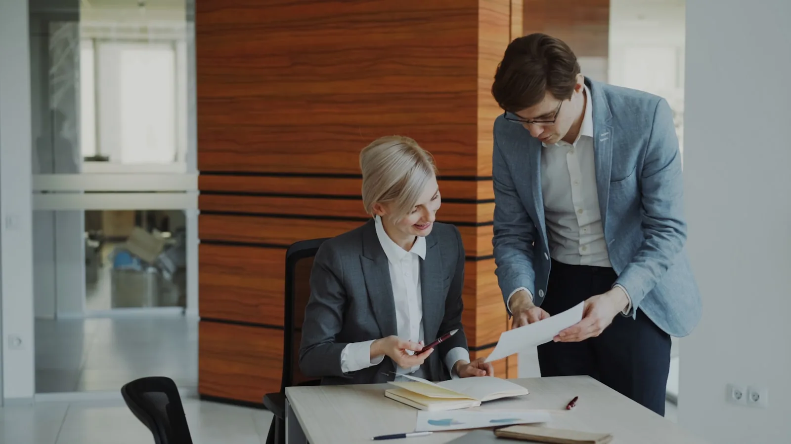Zwei Kollegen prüfen Microsoft-365-Lizenzkosten gemeinsam am Schreibtisch in einem Hamburger Büro