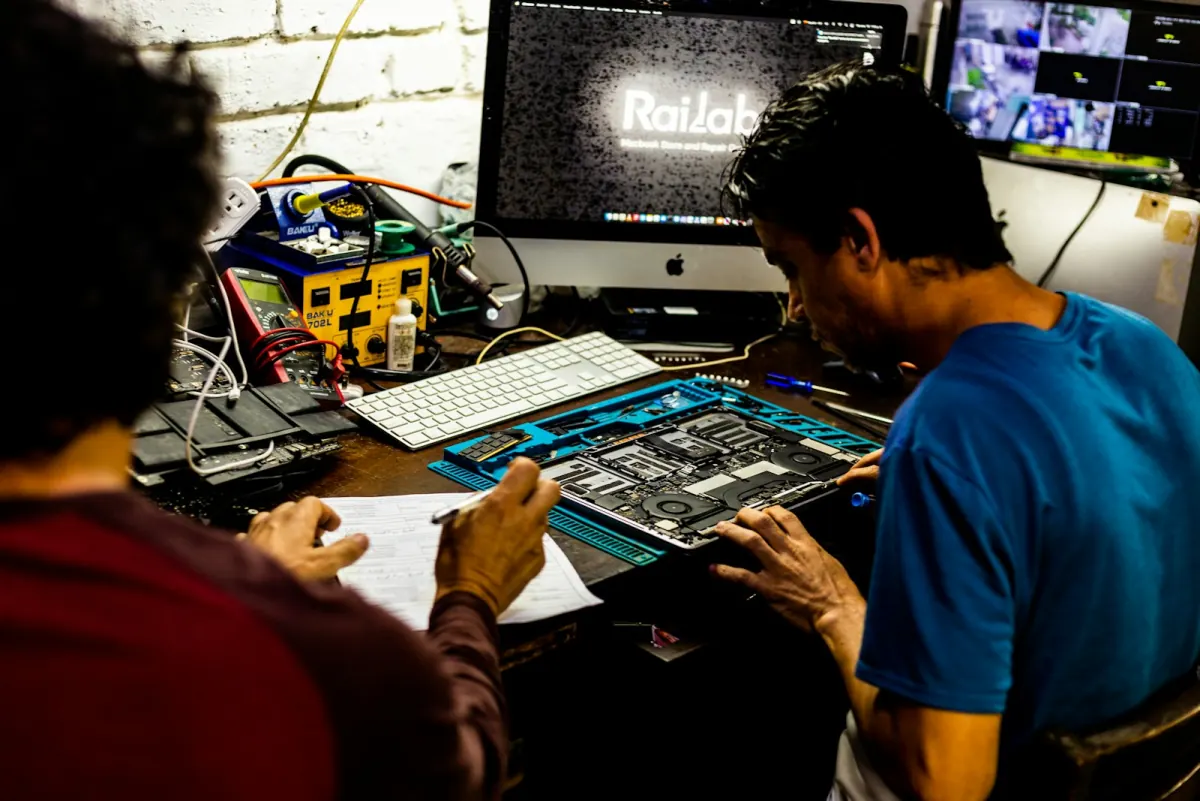 Zwei Netzwerk-Techniker arbeiten an einer Hardware-Platine — OSI Layer 1 und 2 in der Praxis