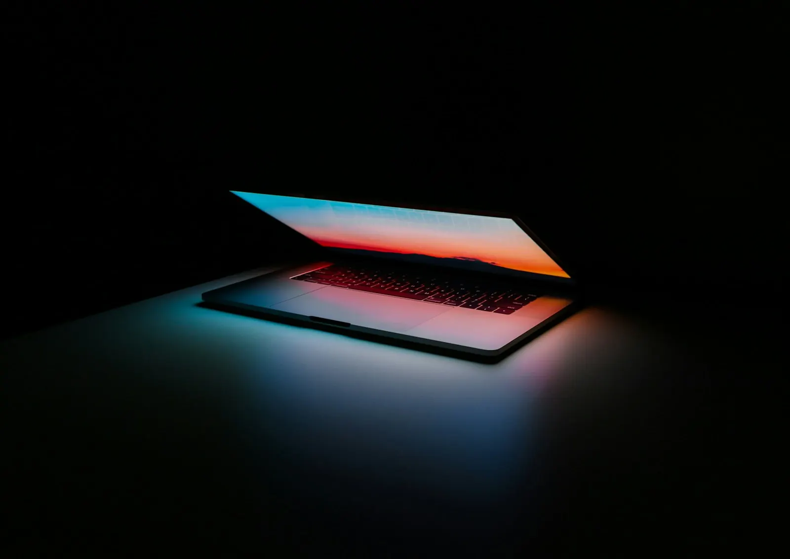 Halb geöffneter Laptop im dunklen Raum als Sinnbild für SaaS-Wildwuchs und unbemerkte Software-Abos