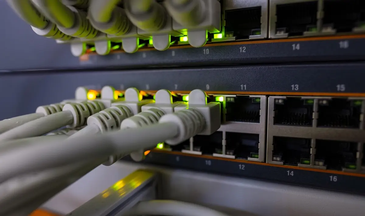 RJ45-Patchkabel im Netzwerk-Switch — TCP/IP-Pakete laufen über das LAN per IPv4 und IPv6