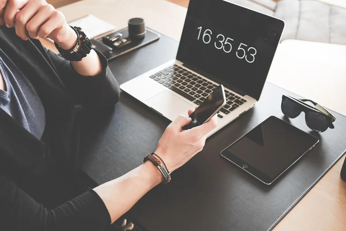 Aufgeräumter Schreibtisch mit Laptop und Smartphone vor dem Windows 11 Rollout