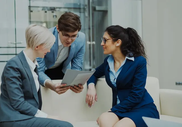 Drei Geschäftsführer prüfen IT-Outsourcing-Vertrag und SLA-Dokumente am Konferenztisch