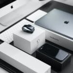 space black case Apple Watch, silver MacBook Pro, jet black iPhone 7 Plus, and silver iMac with corresponding boxes