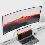 laptop computer beside curved monitor